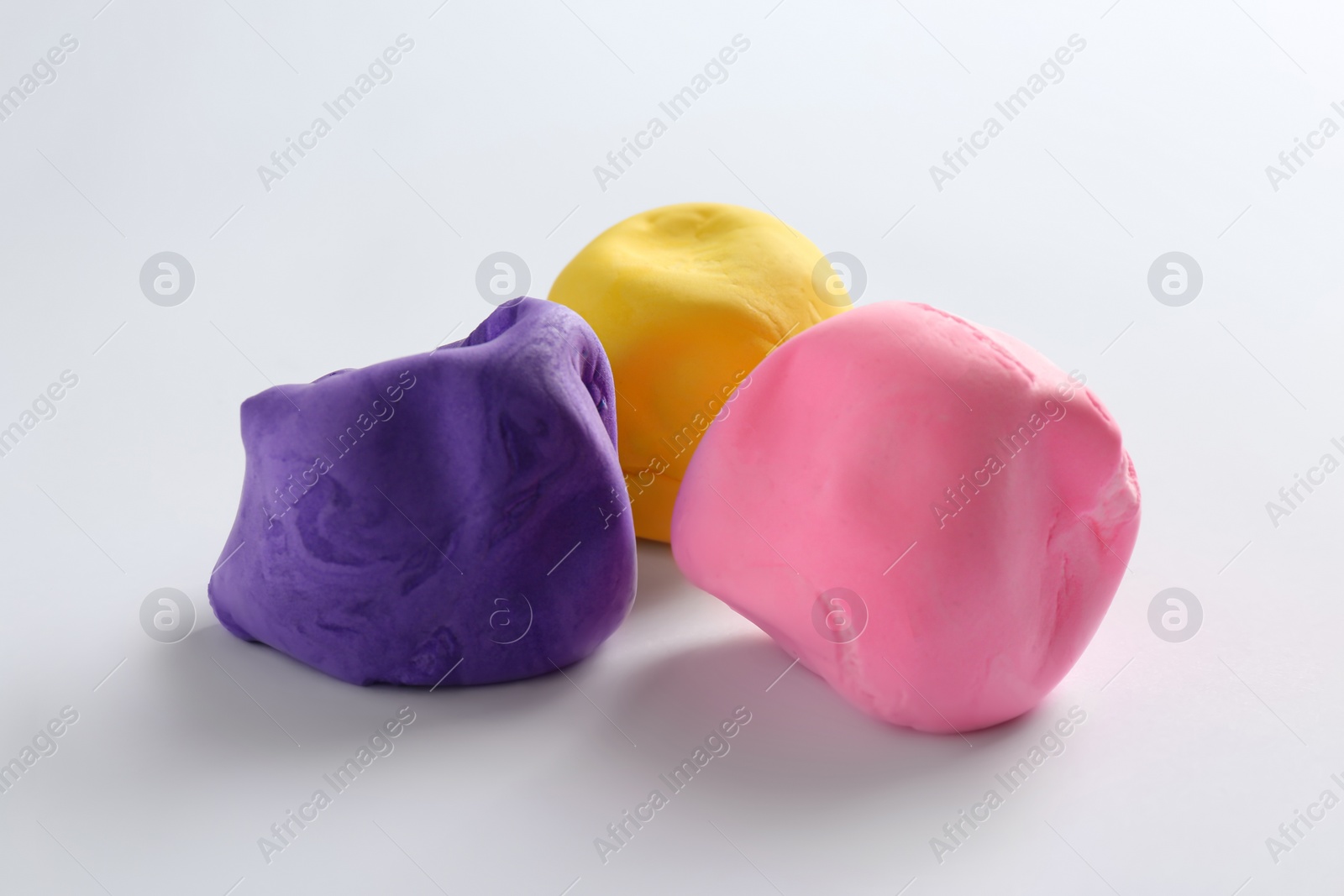 Photo of Different color play dough on white background