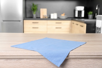 Napkin on wooden table in kitchen. Mockup for design