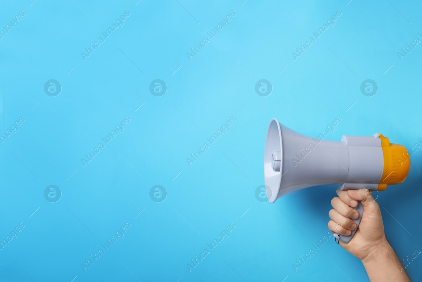 Photo of Man holding megaphone on color background