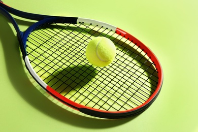Photo of Tennis racket and ball on green background. Sports equipment