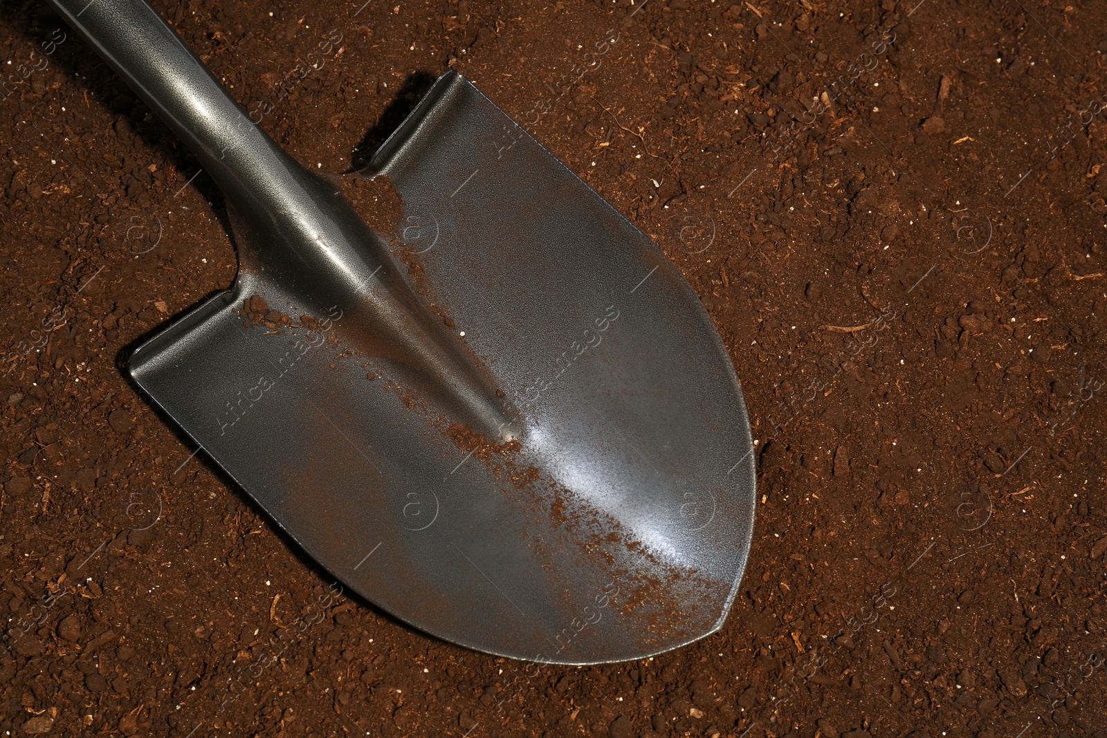 Metal shovel on fertile soil, top view. Gardening tool Photo of Metal shovel on fertile soil, top view. Gardening tool
