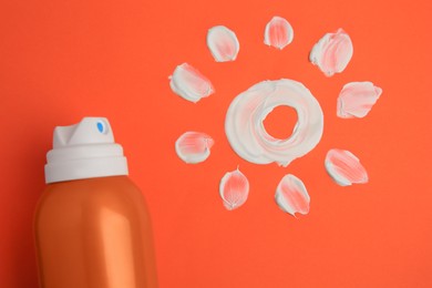 Photo of Drawing of sun and bottle with sunscreen on coral background, top view. Skin protection