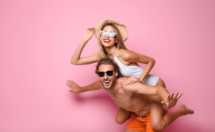 Photo of Happy young couple in beachwear on color background. Space for text