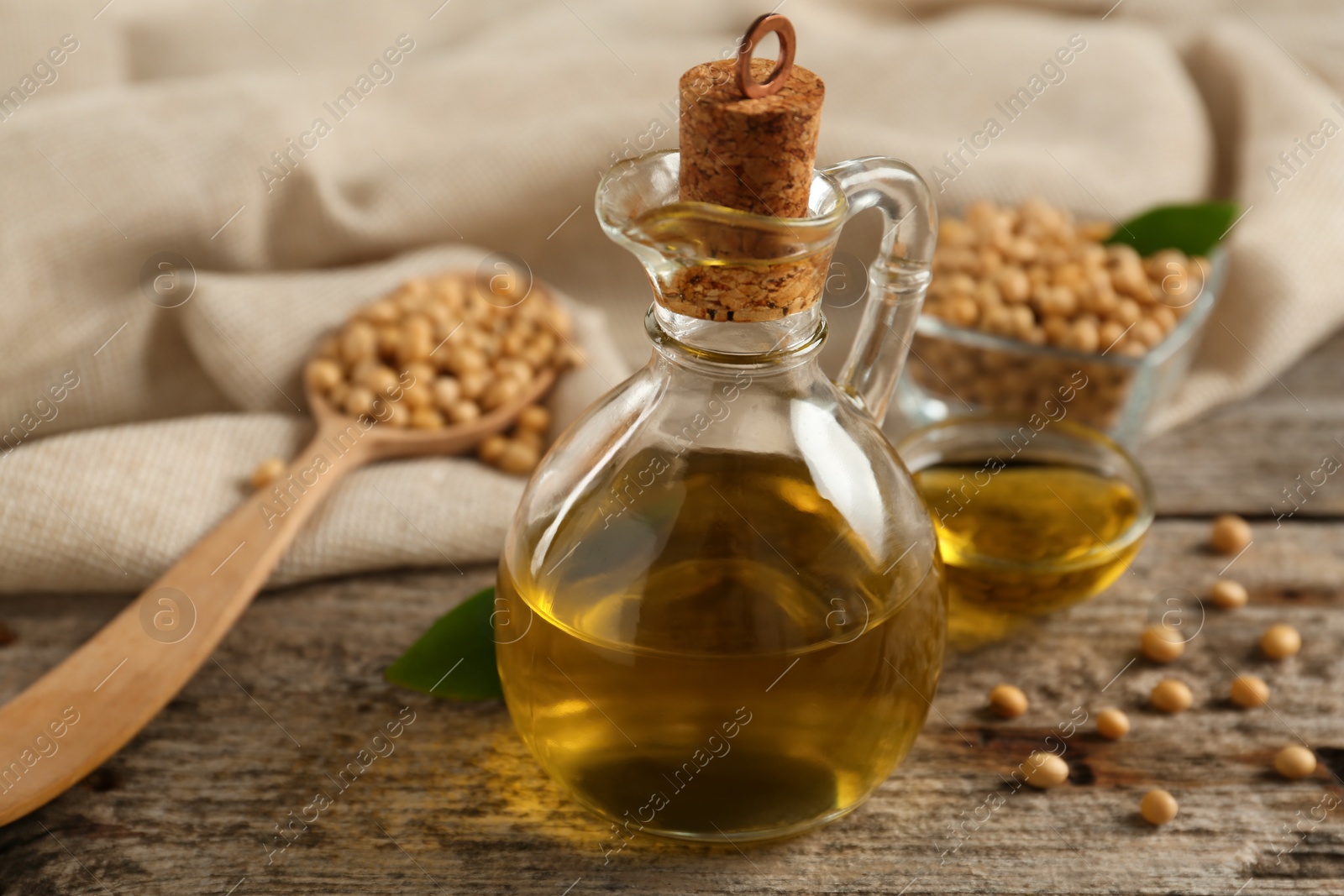 Photo of Composition with soybean oil on wooden table