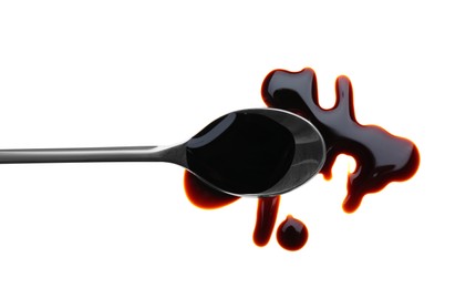 Photo of Spilled soy sauce and spoon on white background, top view