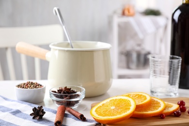 Cut orange, cinnamon sticks and cranberries on table. Mulled wine ingredients