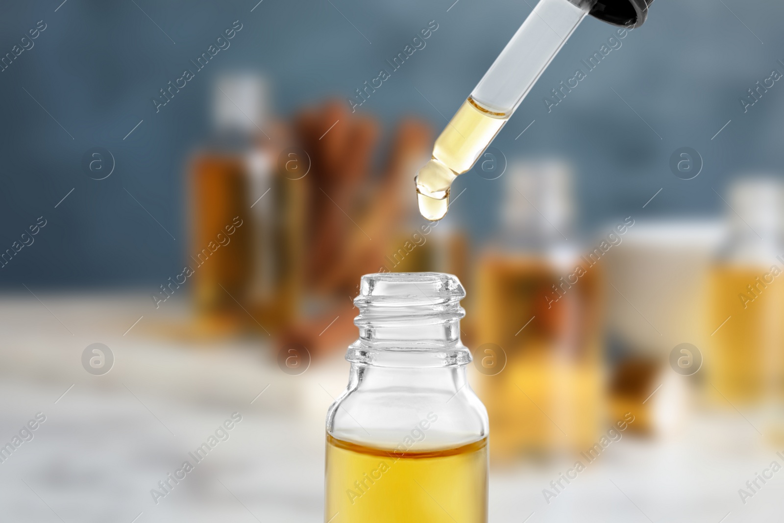 Image of Little bottle with essential oil and dropper against blurred background 