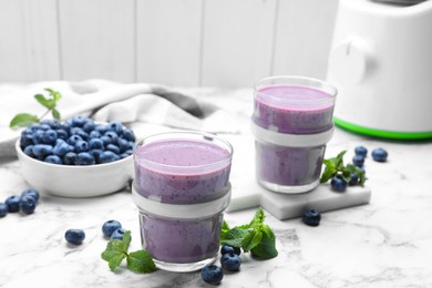 Photo of Tasty blueberry smoothie with mint and fresh berries on white marble table. Space for text