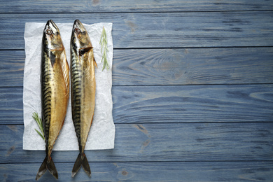 Tasty smoked fish on blue wooden table, top view. Space for text