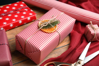 Christmas gift box wrapped with striped paper on wooden table, closeup