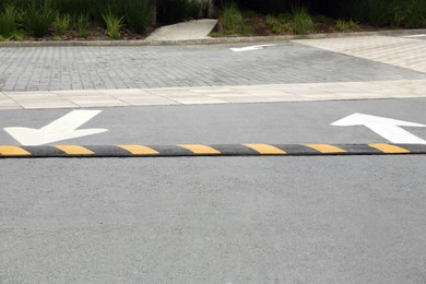 Photo of Striped speed bump on street. Road safety