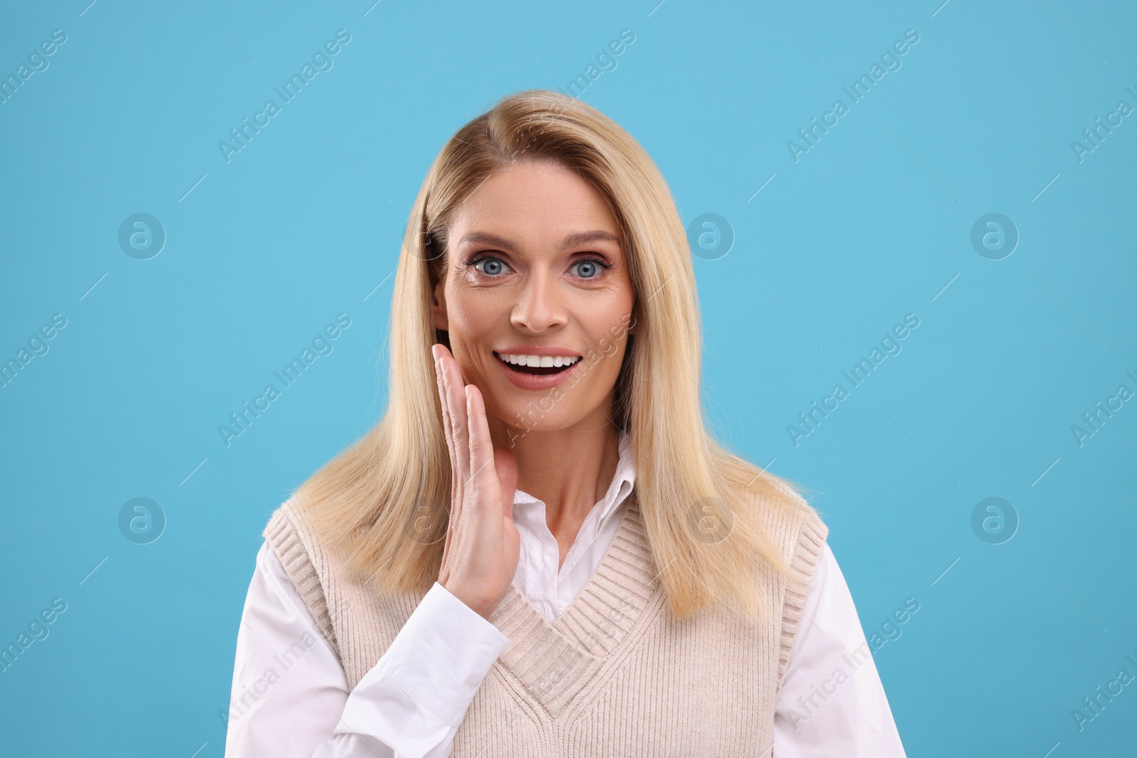 Photo of Portrait of smiling middle aged woman on light blue background