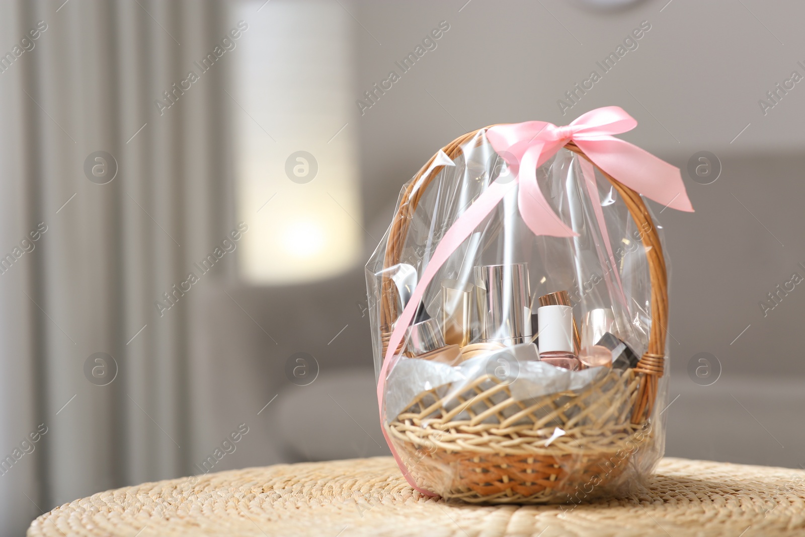 Photo of Wicker basket full of gifts in living room. Space for text