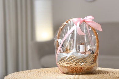 Wicker basket full of gifts in living room. Space for text