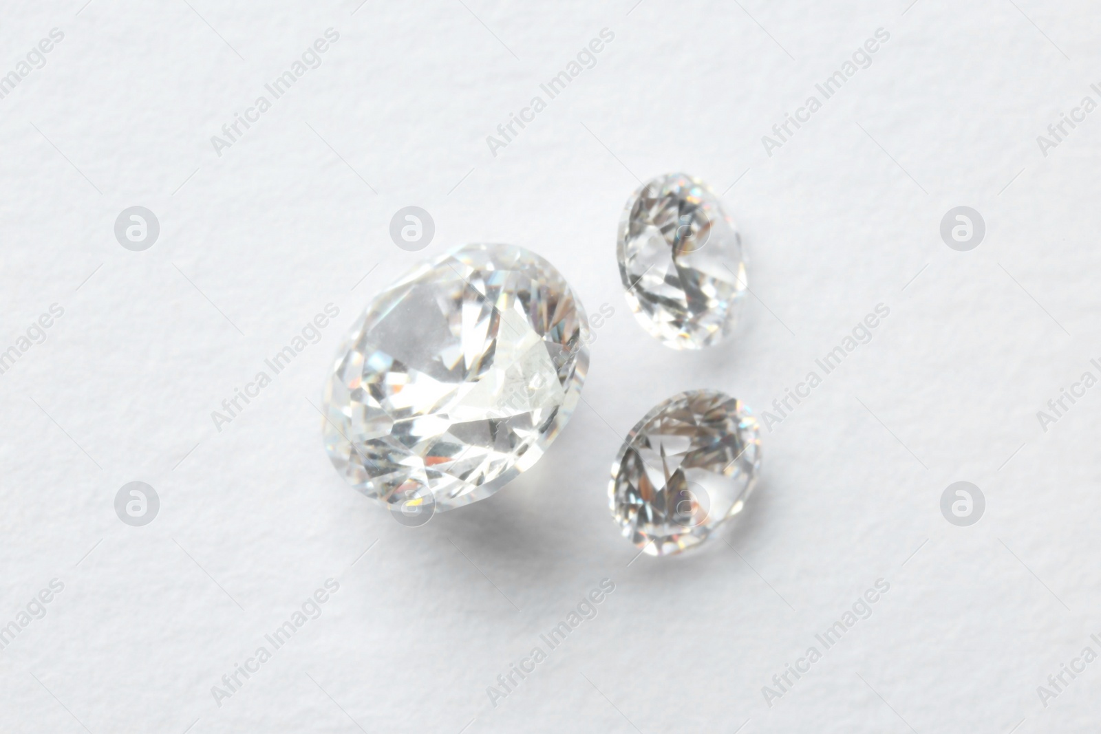 Photo of Beautiful shiny diamonds on white background, flat lay