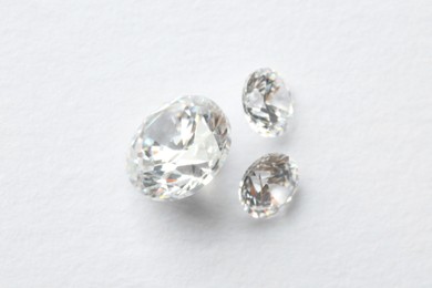 Photo of Beautiful shiny diamonds on white background, flat lay