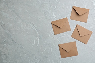 Photo of Brown paper envelopes on grey marble background, flat lay. Space for text