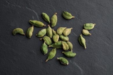 Photo of Dry cardamom pods on black table, top view