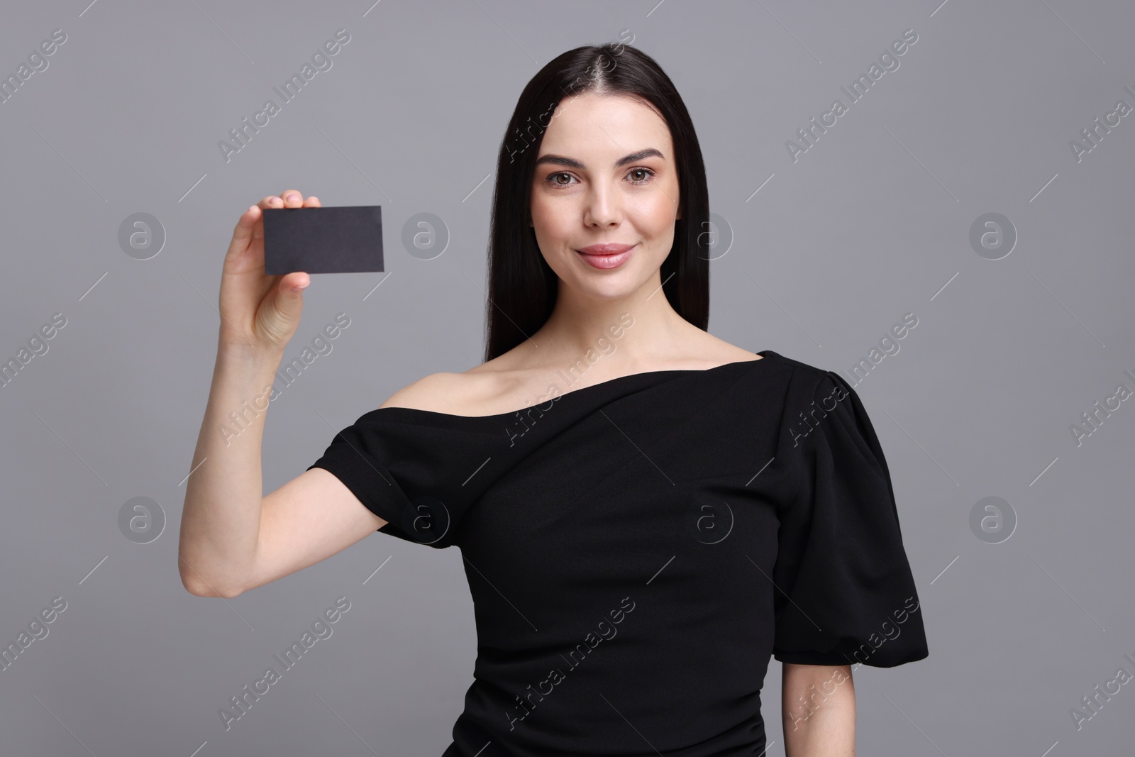 Photo of Woman holding blank business card on grey background