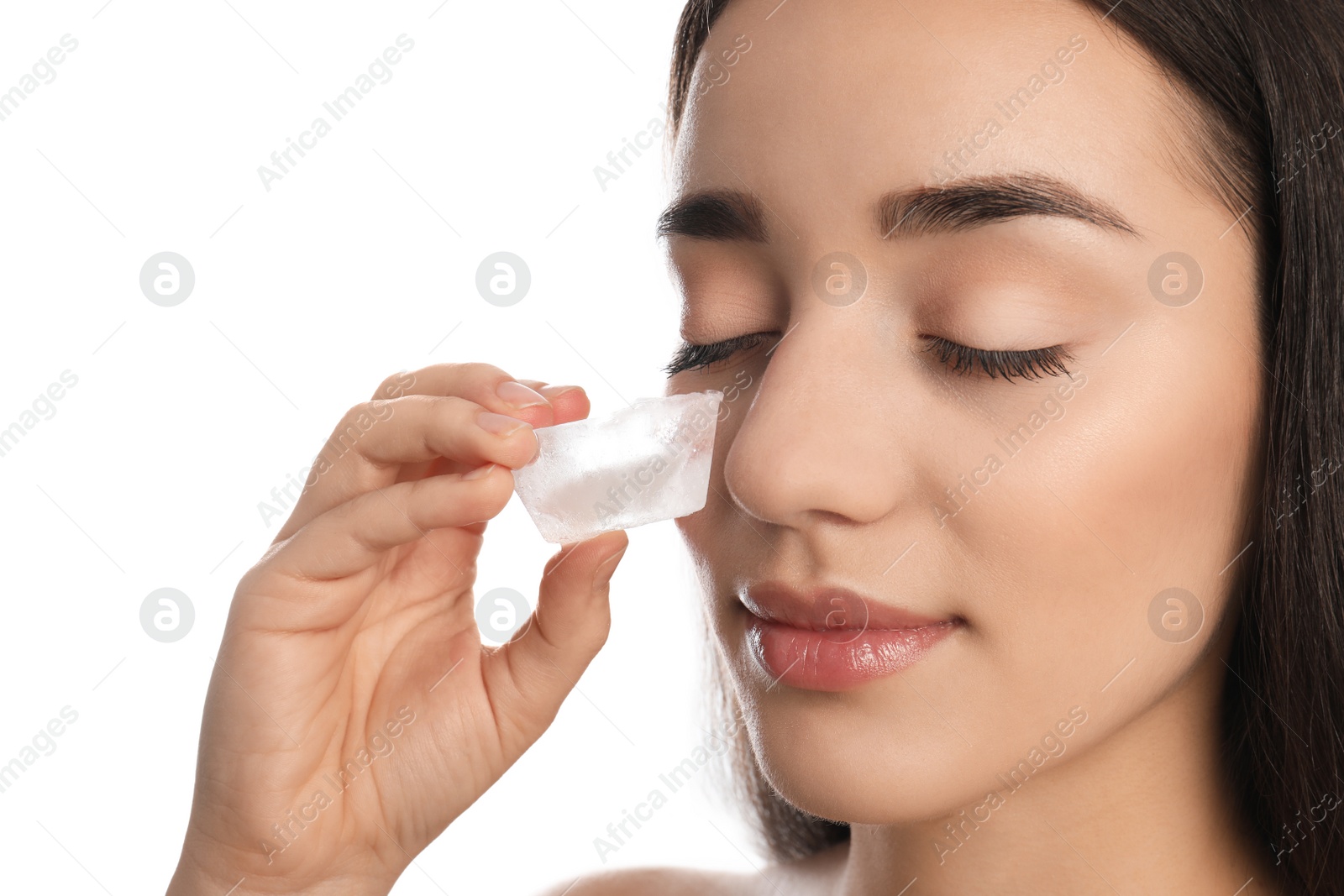 Photo of Young woman with ice cube on white background. Skin care