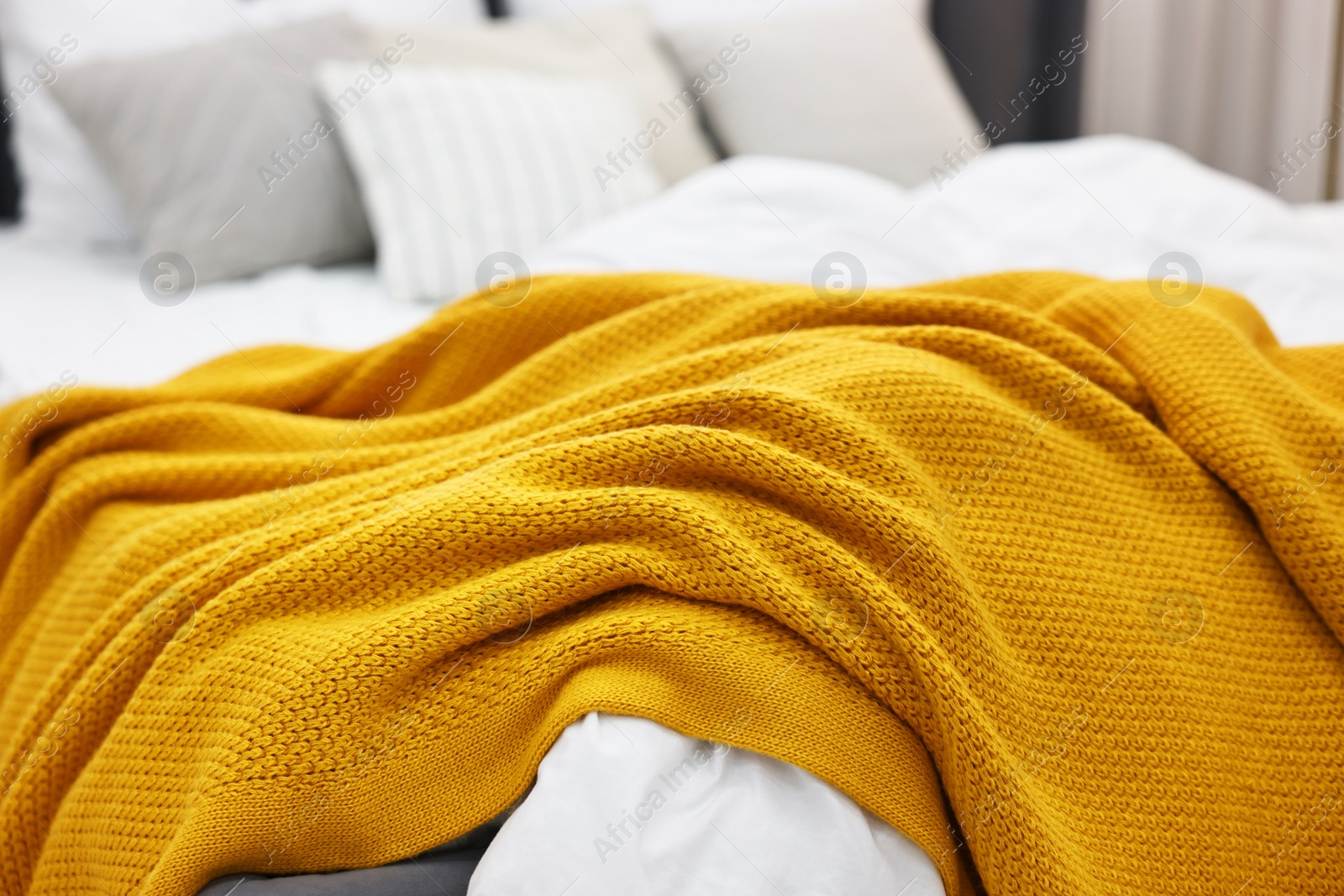 Photo of Soft plaid and pillows on bed in bedroom, closeup