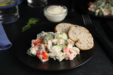 Photo of Delicious salad with mayonnaise on black table
