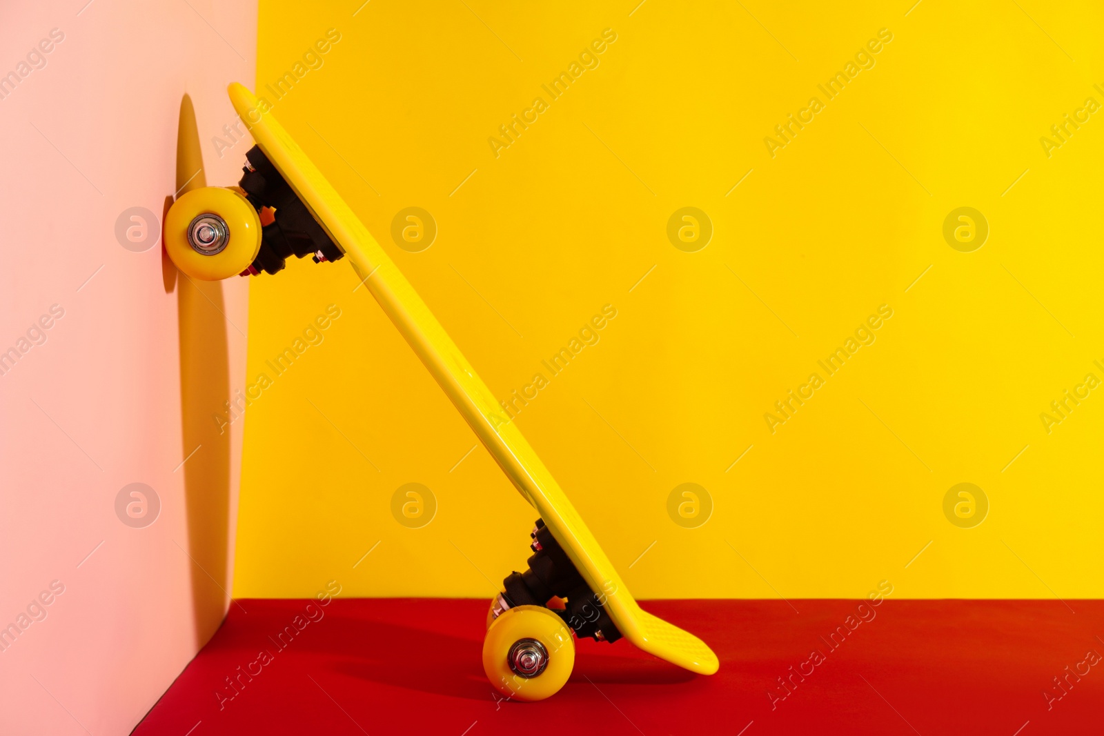 Photo of Yellow skateboard on color background. Space for text