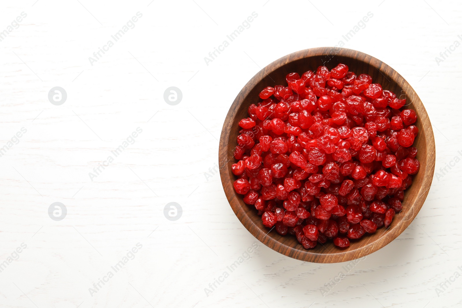 Photo of Bowl of tasty cherries on wooden background, top view with space for text. Dried fruits as healthy food