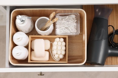 Different bath accessories and personal care products in drawer indoors, top view