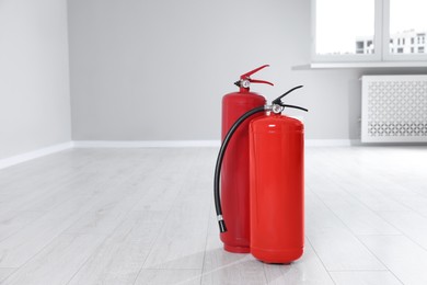 Photo of Fire extinguishers on floor indoors, space for text