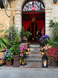 Photo of WARSAW, POLAND - JULY 15, 2022: Beautiful plants and lanterns near entrance in restaurant
