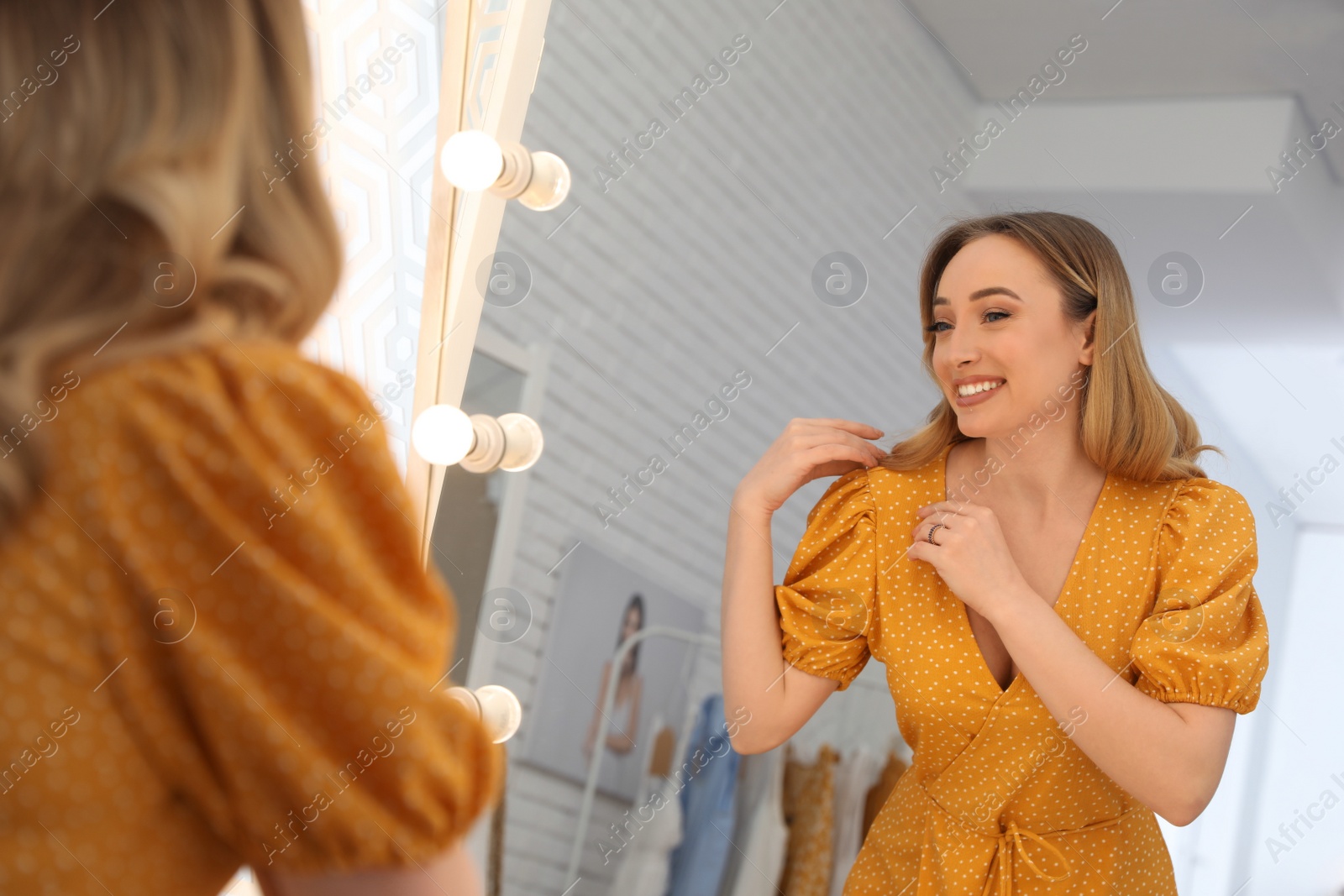 Photo of Woman trying on stylish dress in showroom