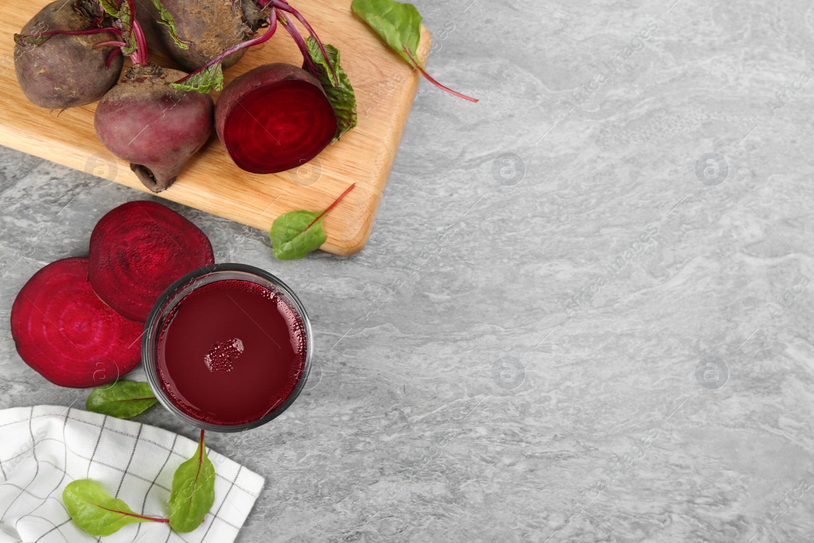 Photo of Freshly made beet juice on grey table, flat lay. Space for text