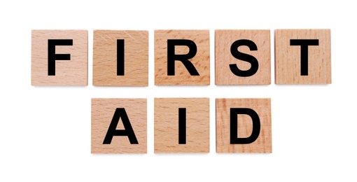 Words First Aid made of wooden cubes isolated on white, top view