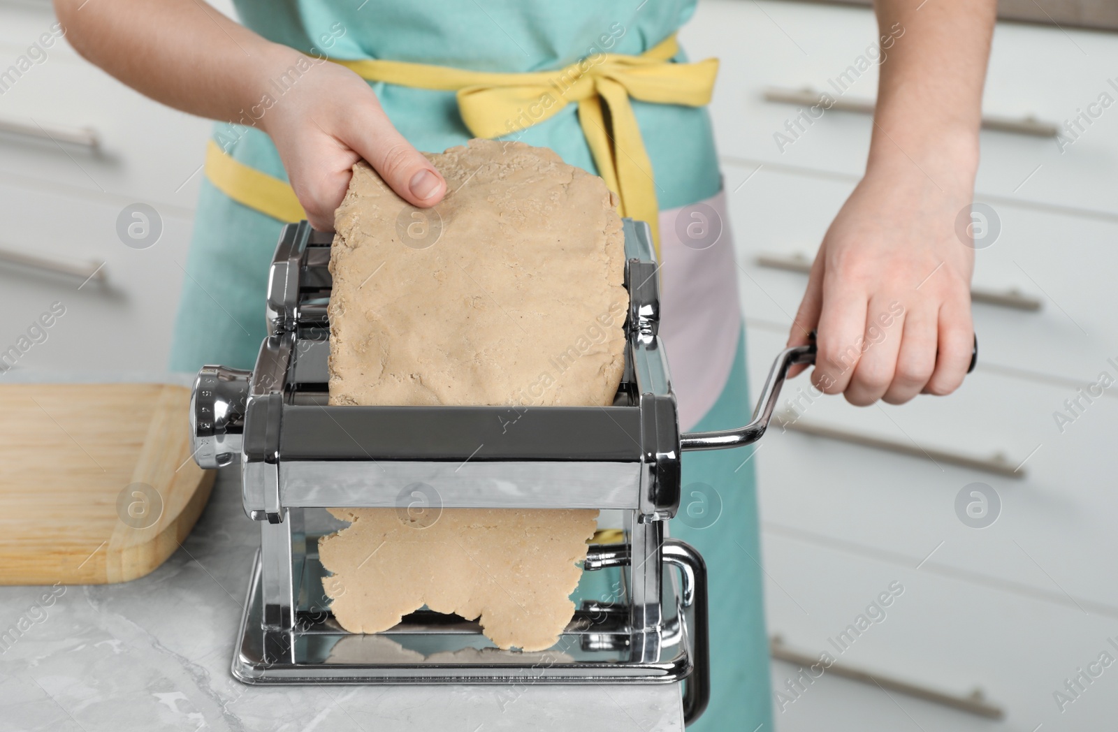 Photo of Woman making dough for soba (buckwheat noodles) at light grey marble table indoors, closeup