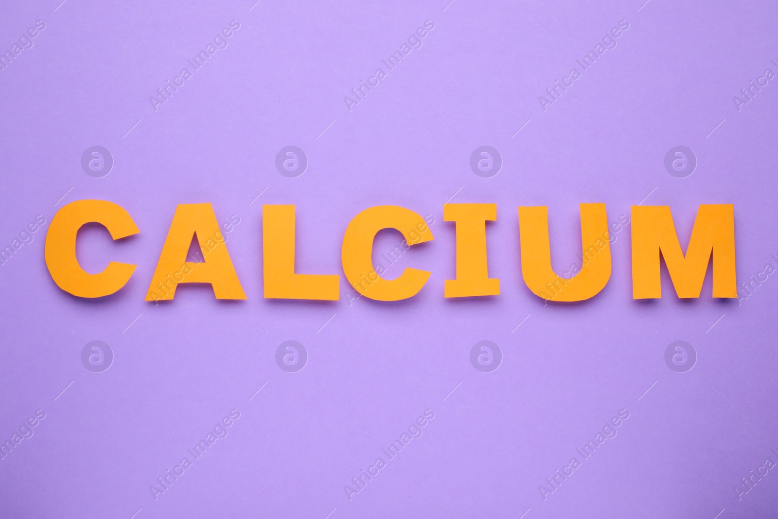 Photo of Word Calcium made of orange paper letters on violet background, top view