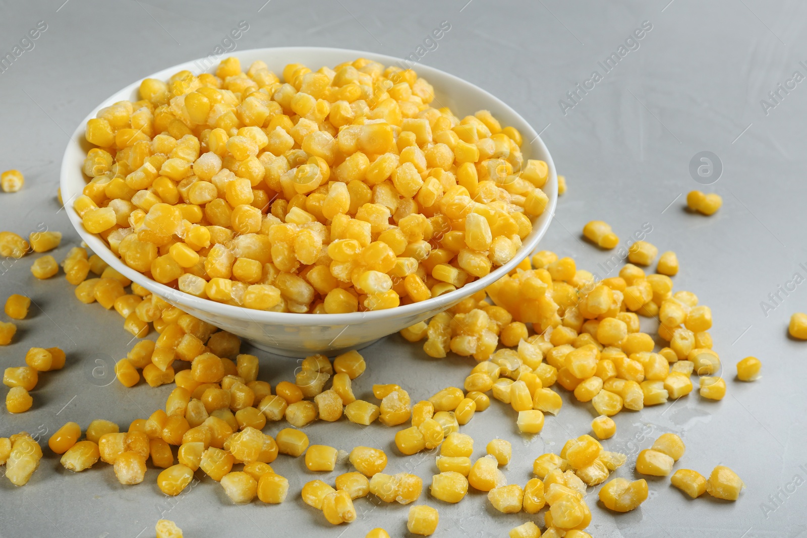 Photo of Frozen corn on light grey table. Vegetable preservation