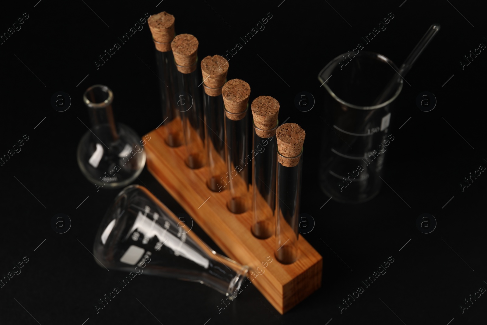 Photo of Different laboratory glassware on black background, closeup