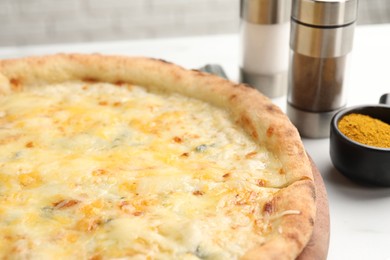 Photo of Delicious cheese pizza and spices on white table, closeup