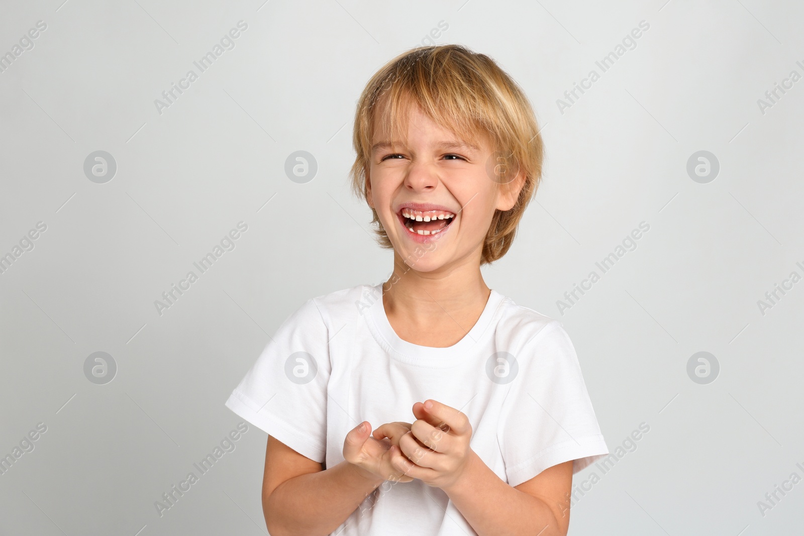 Photo of Happy little boy on light grey background