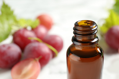 Photo of Bottle of natural grape seed oil, closeup with space for text. Organic cosmetic