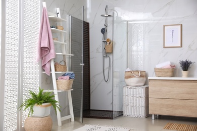 Photo of Bathroom interior with shower stall and shelving unit. Idea for design