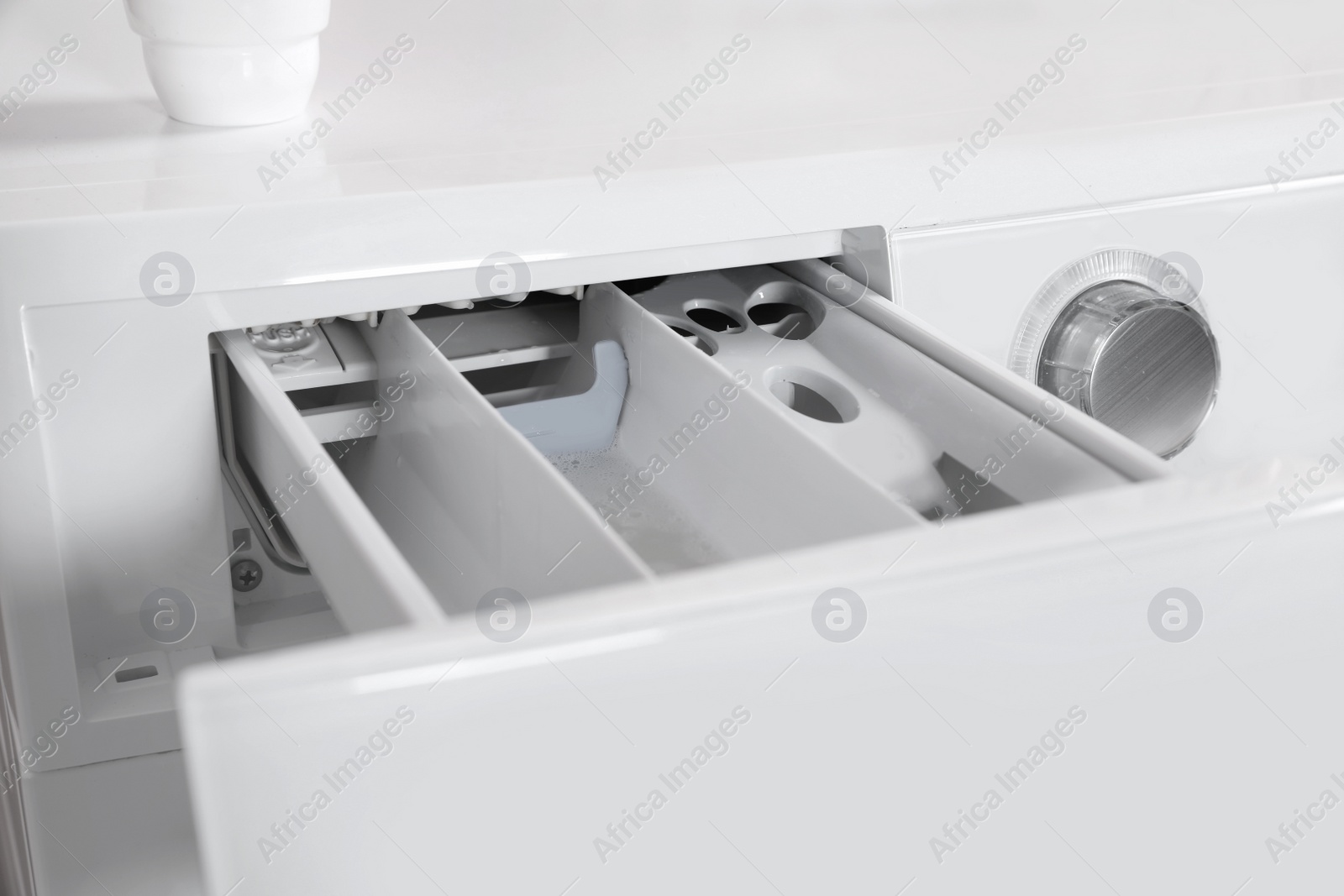 Photo of Washing machine with open detergent drawer, closeup. Laundry day