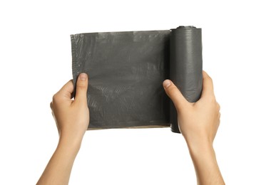 Photo of Woman holding roll of grey garbage bags on white background, closeup. Cleaning supplies
