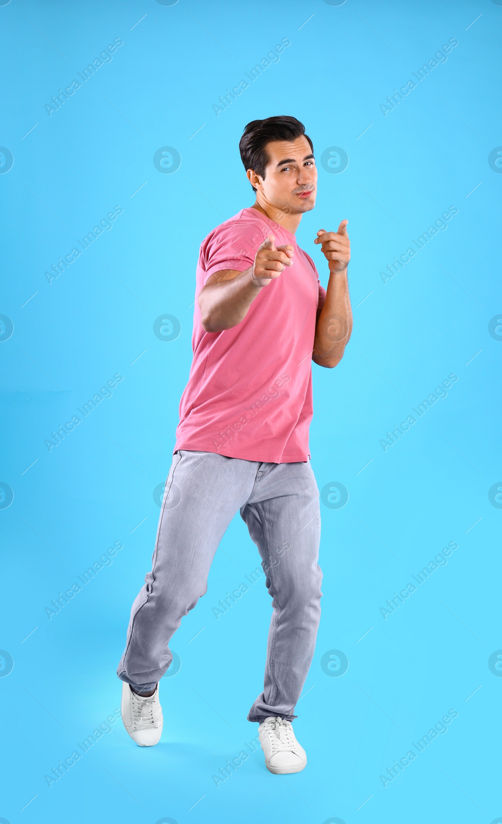 Photo of Handsome young man dancing on blue background