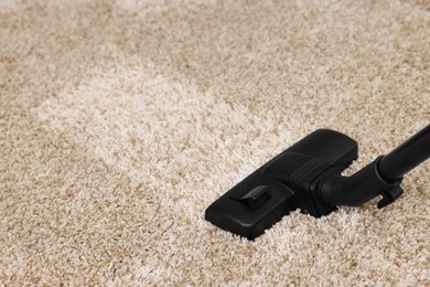 Photo of Hoovering carpet with vacuum cleaner, space for text