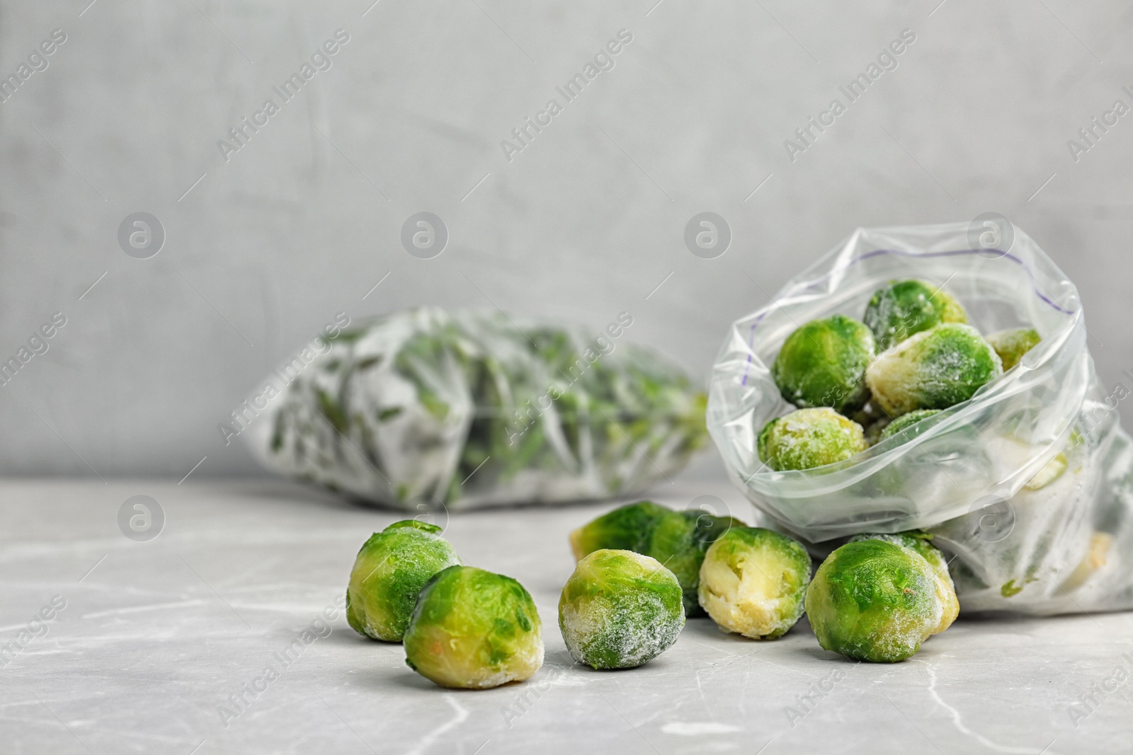 Photo of Plastic bag with frozen Brussel sprouts on table. Vegetable preservation