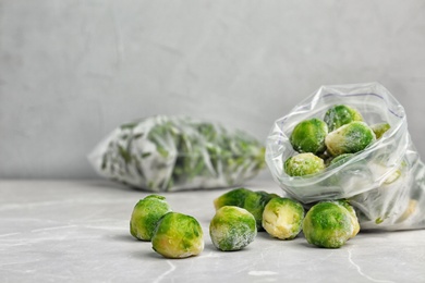Photo of Plastic bag with frozen Brussel sprouts on table. Vegetable preservation