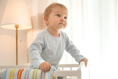 Cute little baby in crib at home