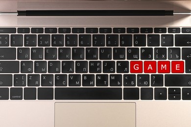 Image of Red buttons with letters G A M E on laptop keyboard, top view